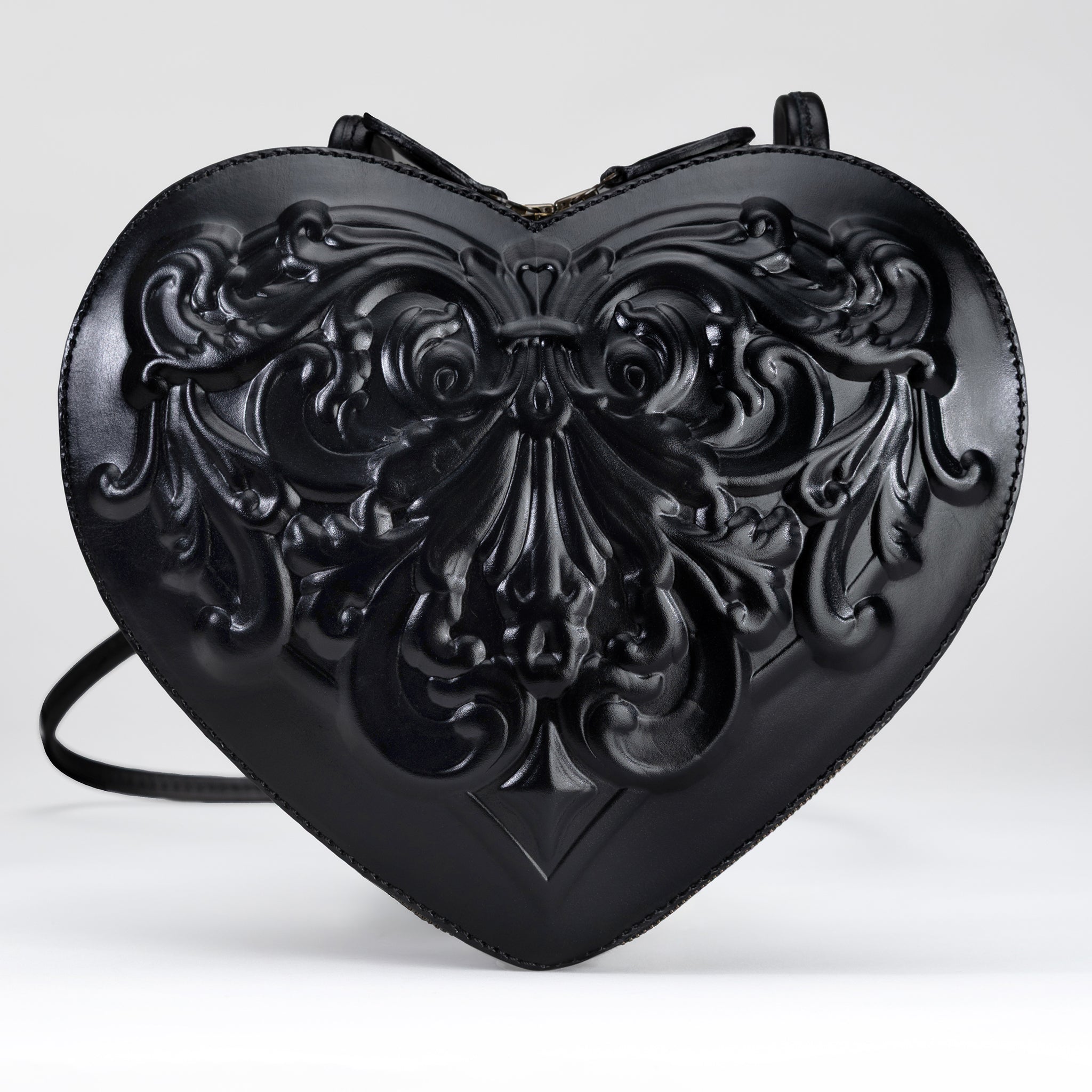 Front view of handmade heart-shaped leather bag in black vegetable-tanned calfskin, featuring 3D sculpted baroque relief and silver-tone nickel hardware. A Renaissance-inspired artisan piece.